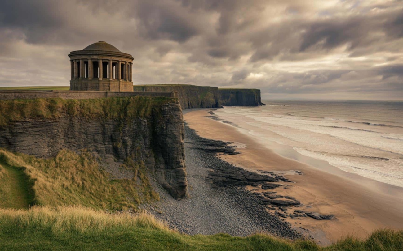 Mussenden Temple perched on the Downhill cliffs above the long sweep of sand next to Castlerock under a dramatic sky