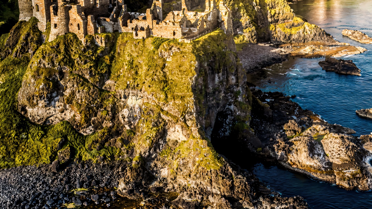 Dunluce Castle perched on its sea cliff, seen from the water