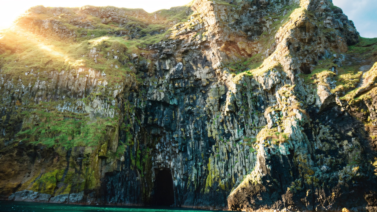 A sea cave in the cliff face, best appreciated from a boat