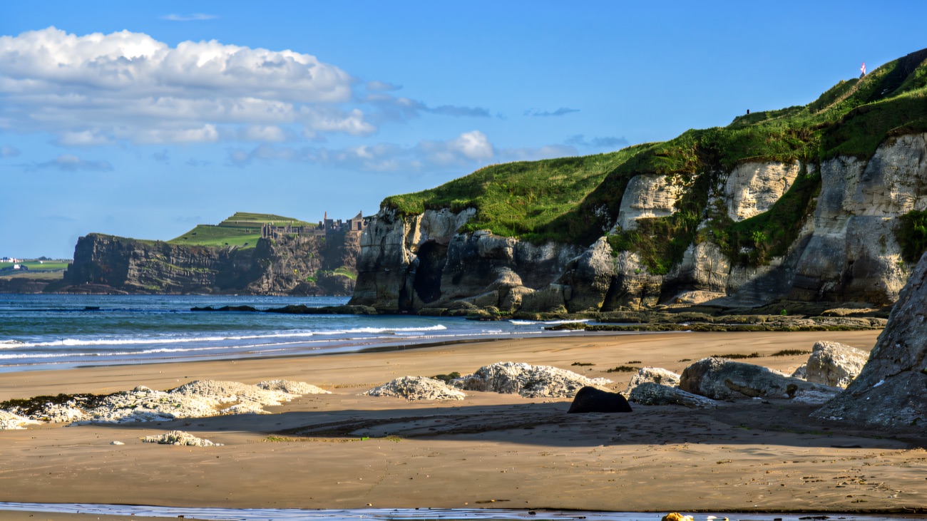 Whiterocks beach with Dunluce Castle on the chalk cliffs beyond