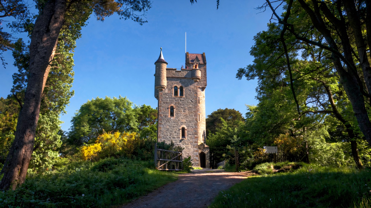 Helen's Tower rising from the trees on the Clandeboye Estate under a blue sky