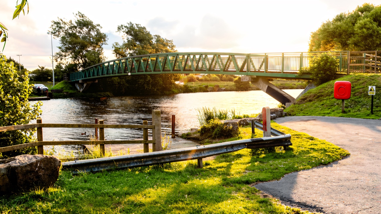 The green iron footbridge arcing over the water
