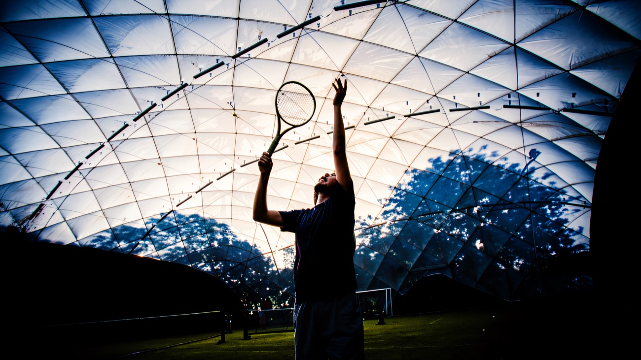 A serve under the tennis dome at dusk