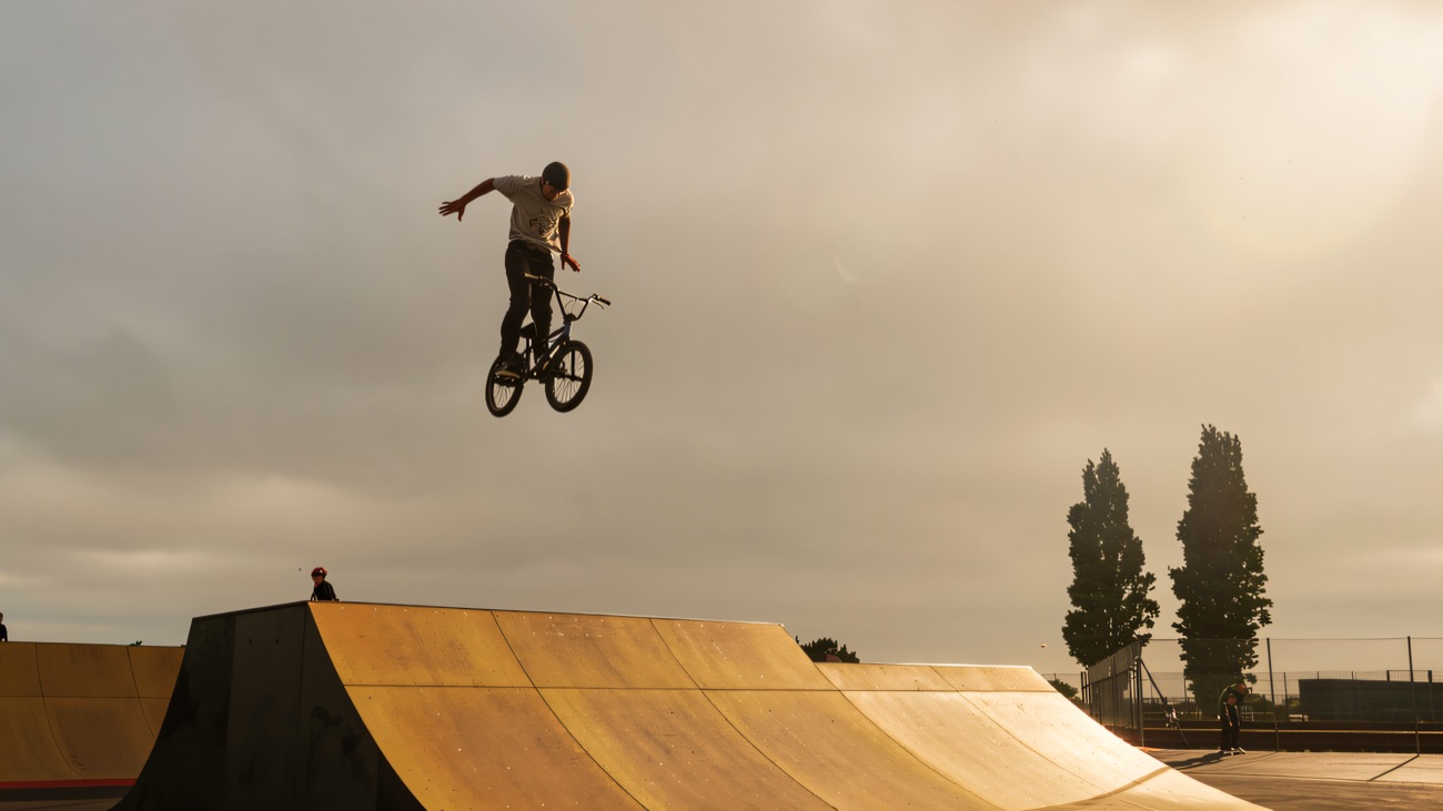 A BMX rider high above the ramps against an open sky