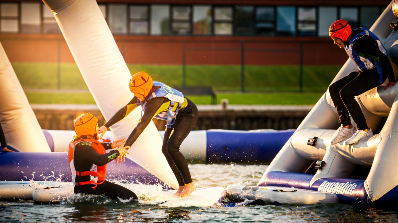 Scrambling across the aqua-park inflatables, a helping hand and a big splash