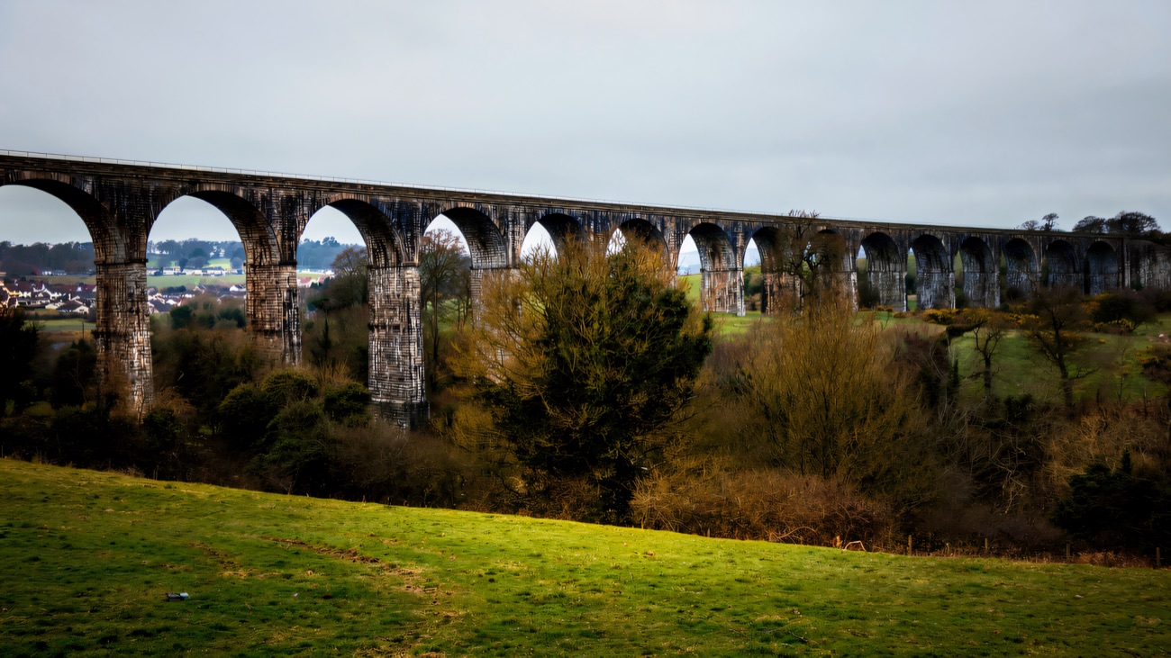 The full span striding across the valley, seen side-on under a soft winter sky.