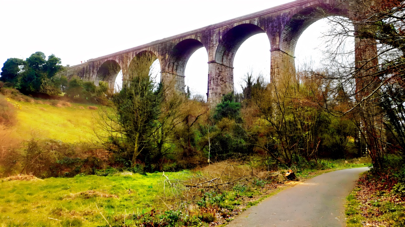 The walking path leading up towards the towering stone arches.