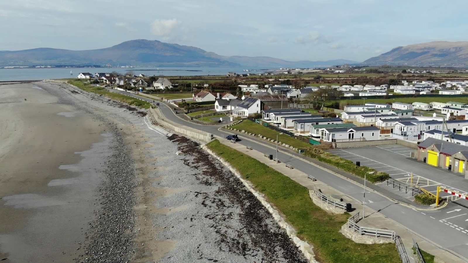 Aerial view of the sandy beach and promenade at Cranfield near Kilkeel, backed by caravan parks, with the Cooley Mountains rising across Carlingford Lough