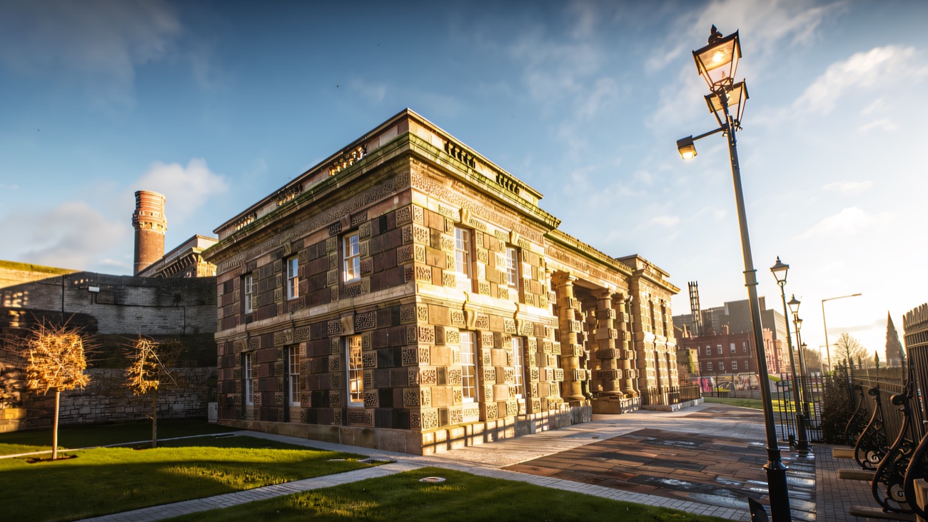 Charles Lanyon's 1840s gaol on the Crumlin Road, its patterned basalt-and-sandstone walls warmed by low winter sun.