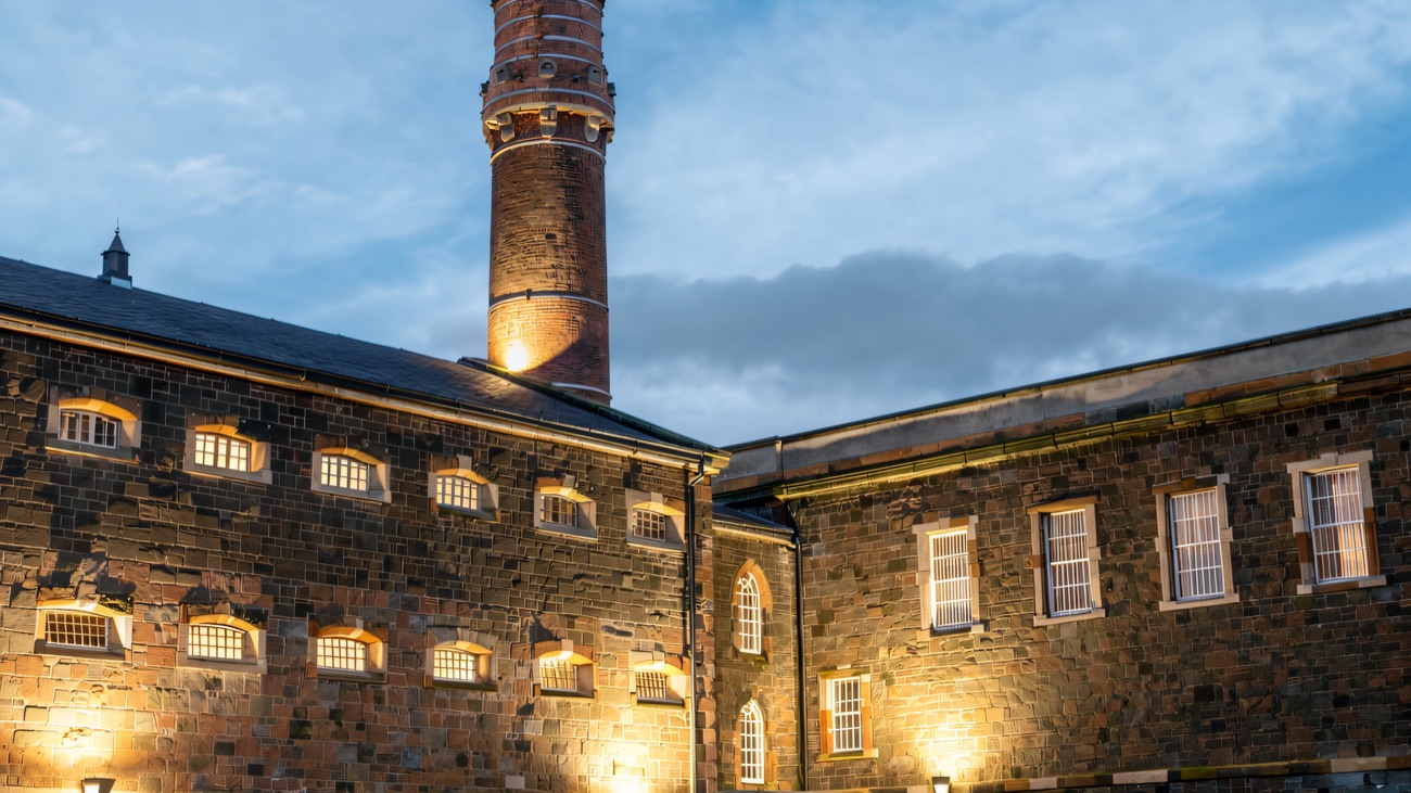 The tall brick ventilation chimney rising above the barred windows of the prison wings.
