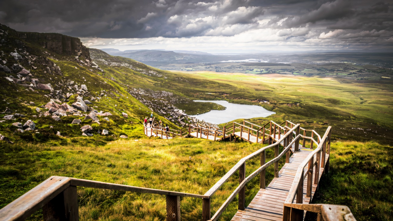 A brooding sky over the escarpment and the pool the boardwalk climbs toward.