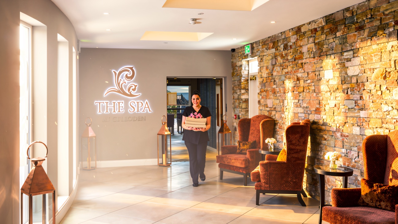 The warm-stone spa reception, with deep armchairs and soft lighting.