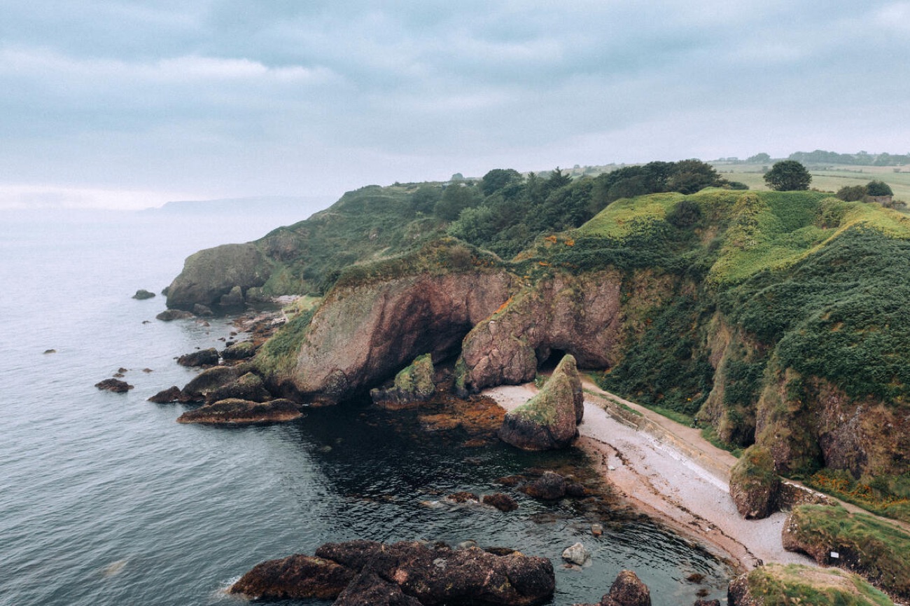 The red sandstone sea caves and cliffs along the shore at Cushendun