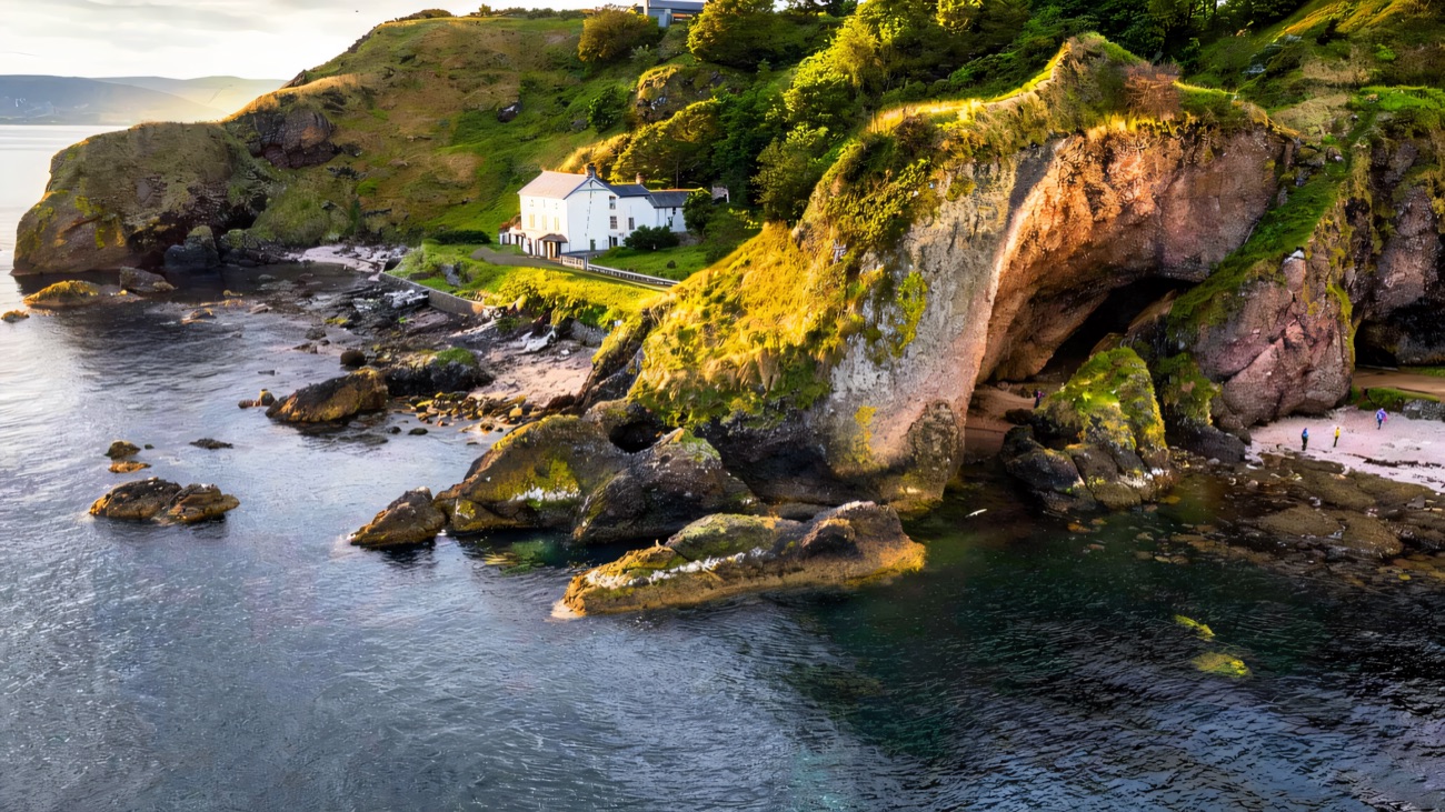 Aerial of Cave House and the red sandstone caves at Cushendun
