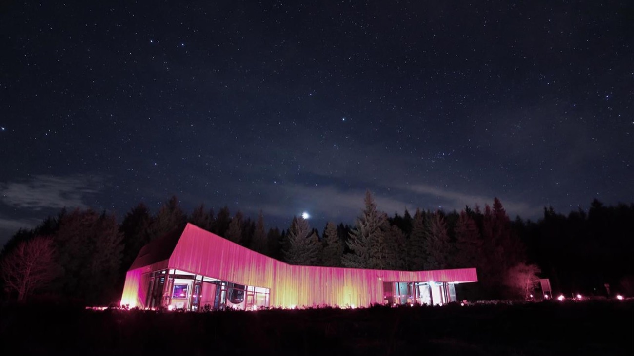 The OM observatory building glowing warm against a star-filled Sperrin night sky.