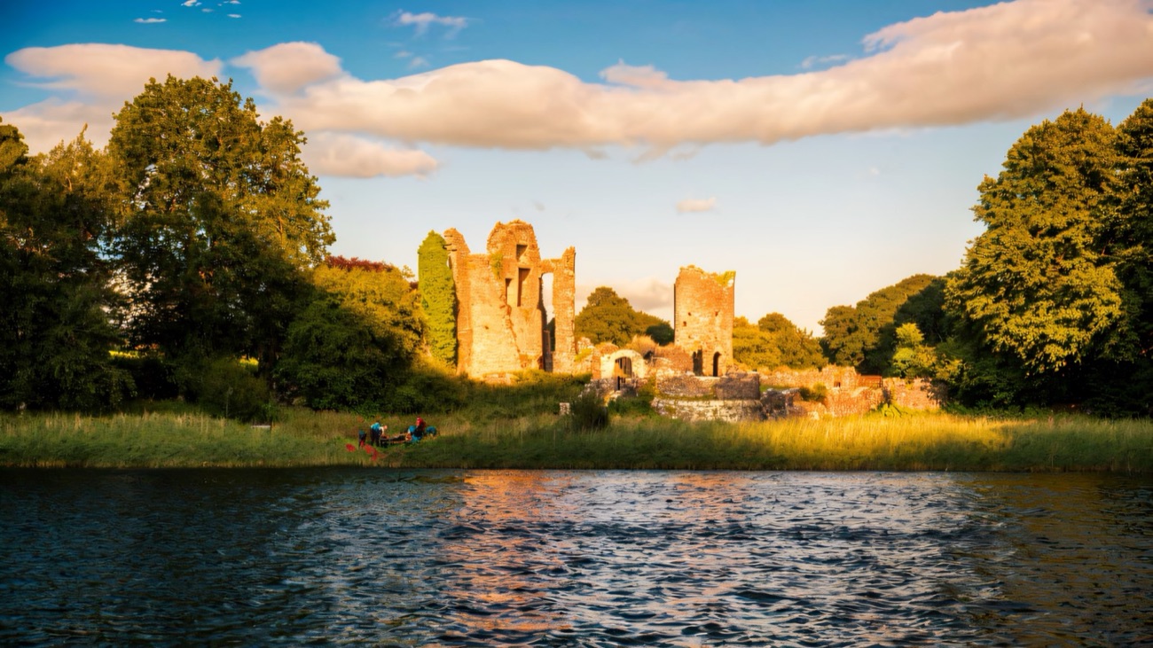 The Old Castle ruins at Crom Estate glowing gold across the water of Upper Lough Erne