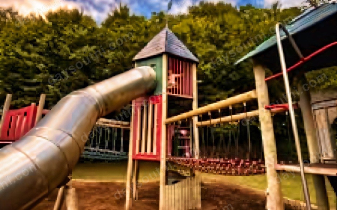 The adventure playground at Delamont Country Park with a tall timber play tower and slides among the trees