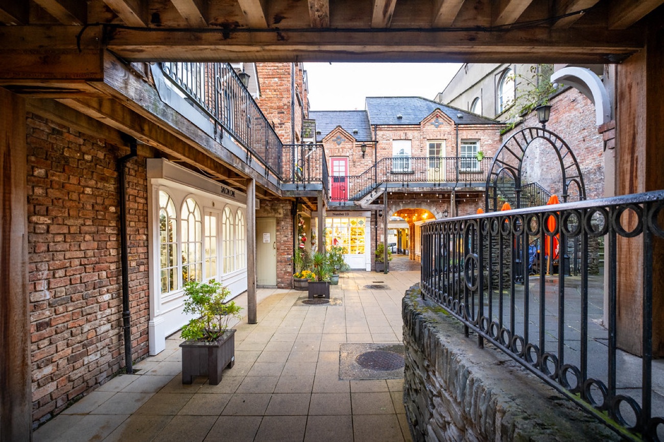 A brick-and-glass laneway in Derry's Craft Village, a short walk from the mural