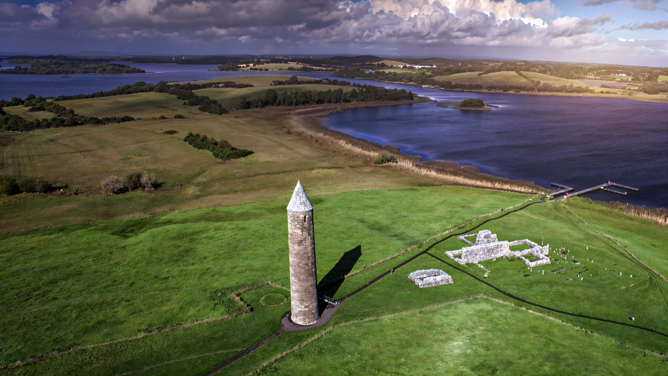 Aerial view of the round tower and ruins on the green island of Devenish, ringed by Lough Erne