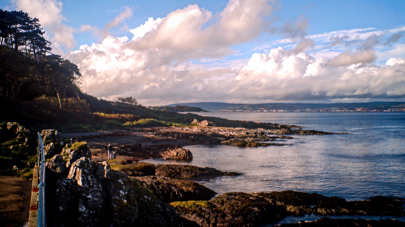 The rocky shore and coastal path at Crawfordsburn with Belfast Lough beyond