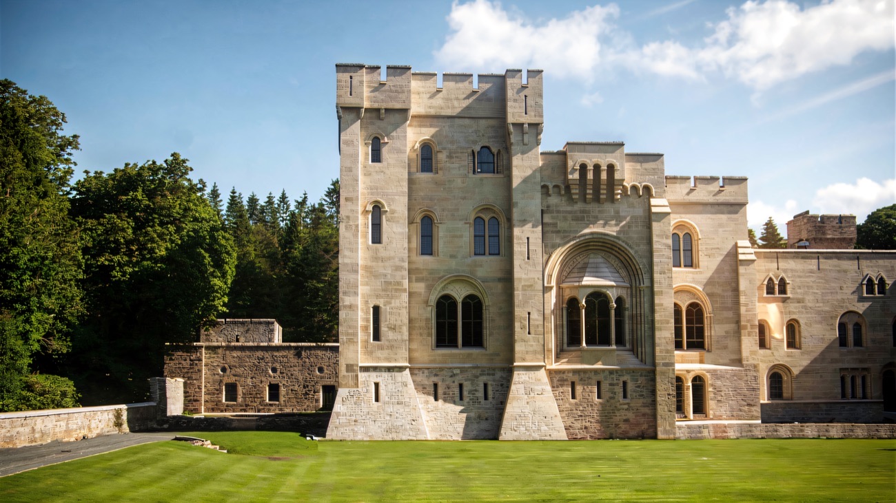 The pale stone towers of Gosford Castle above green lawns at Gosford Forest Park