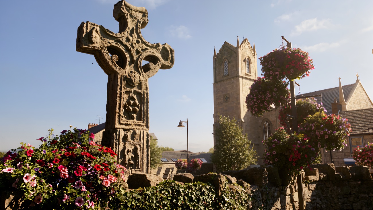 A different angle takes in the cross beside the parish church tower, framed by summer flower baskets.