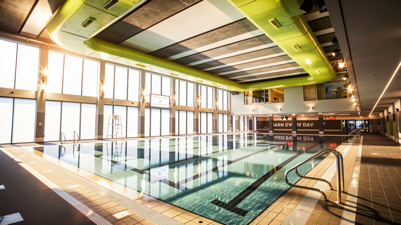 The bright main pool with its timber ceiling and wide glass wall