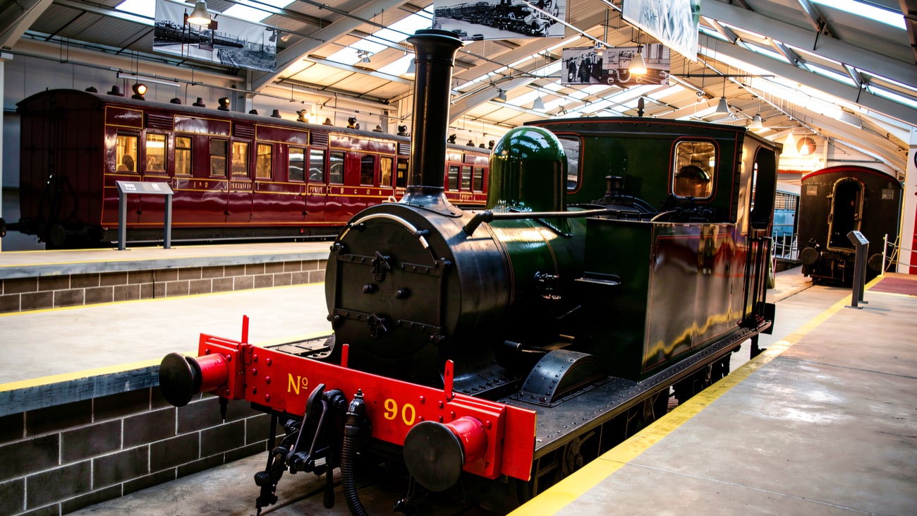 Restored engines and heritage carriages under the roof of the railway's carriage gallery.
