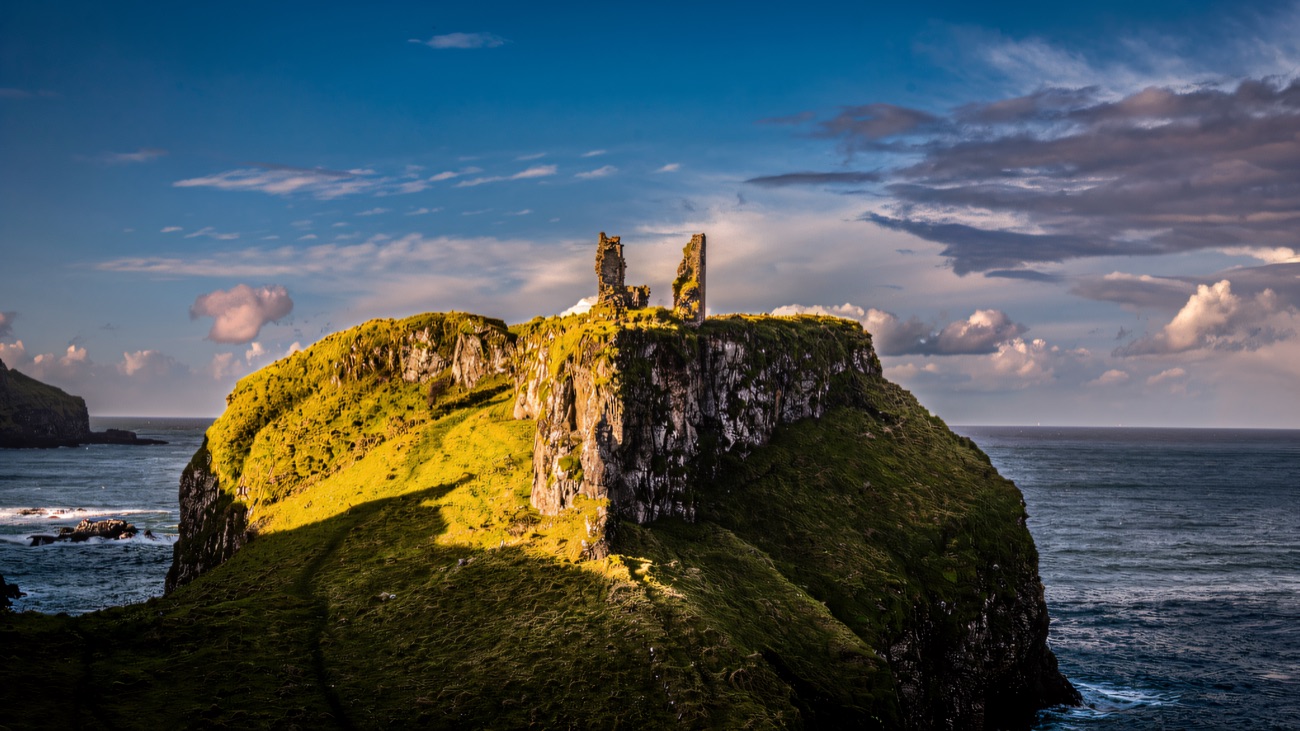 The last standing fragment of wall stands stark against a big Antrim sky.