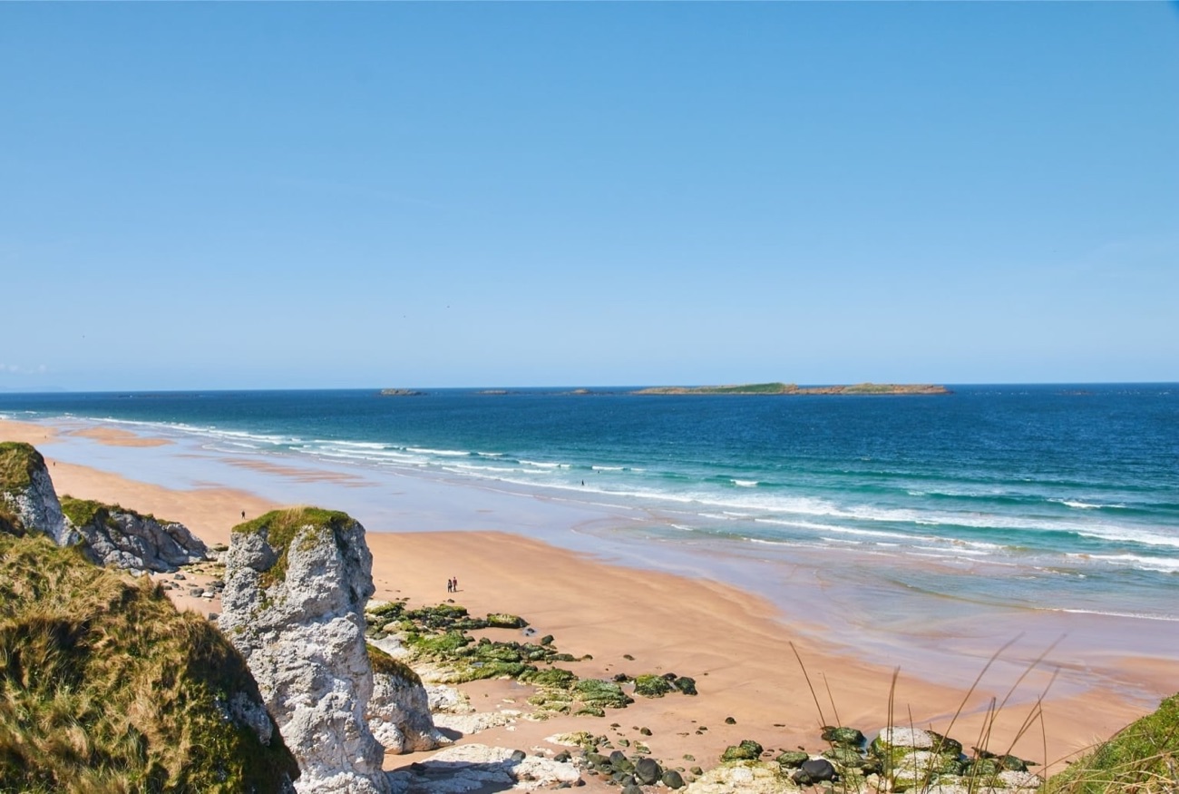 The white chalk sea stacks at Whiterocks at the eastern end of the beach, with turquoise water and golden sand