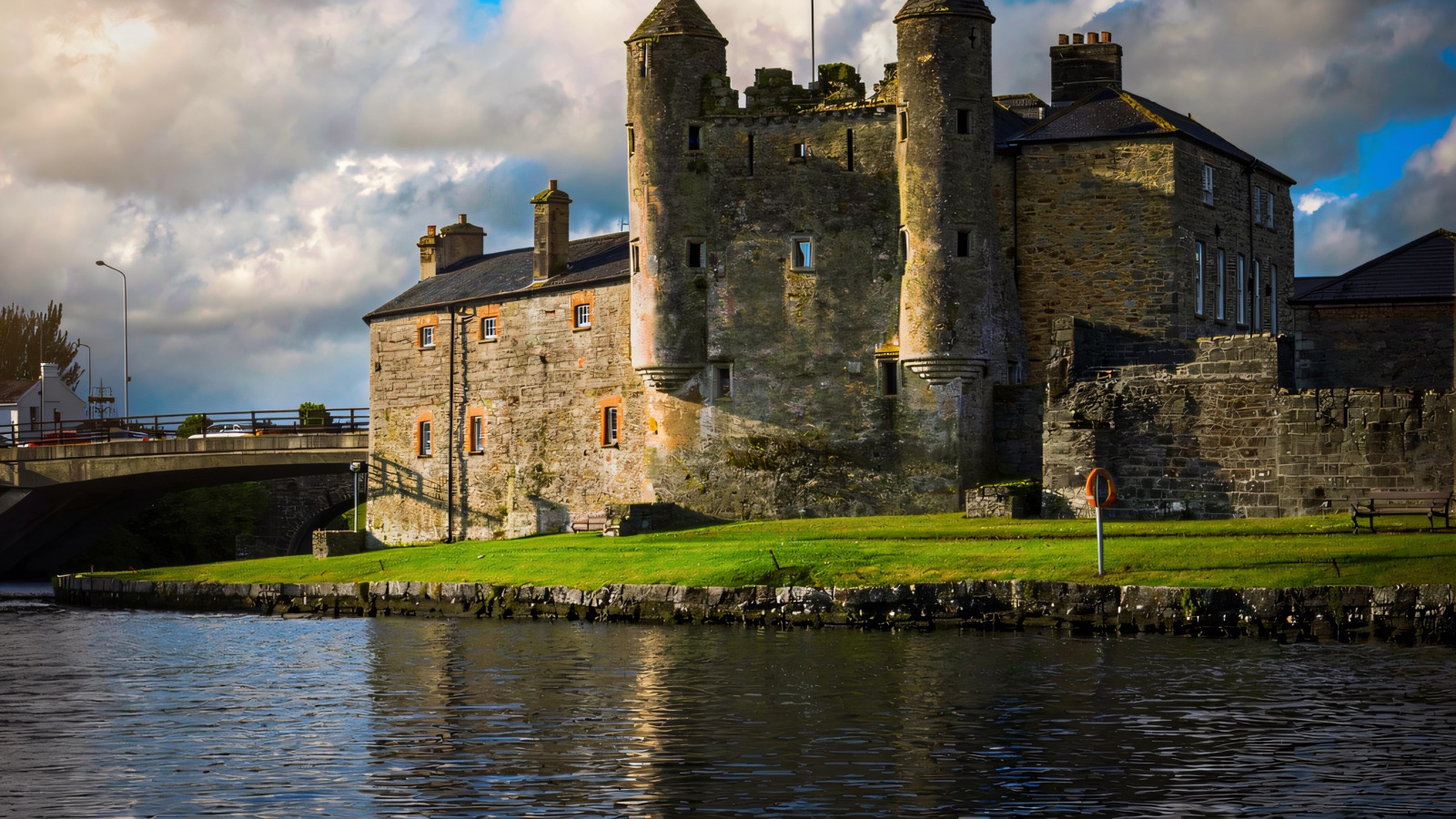 Enniskillen Castle across the River Erne — the twin-turreted Watergate and grey stone keep, with a flag flying above