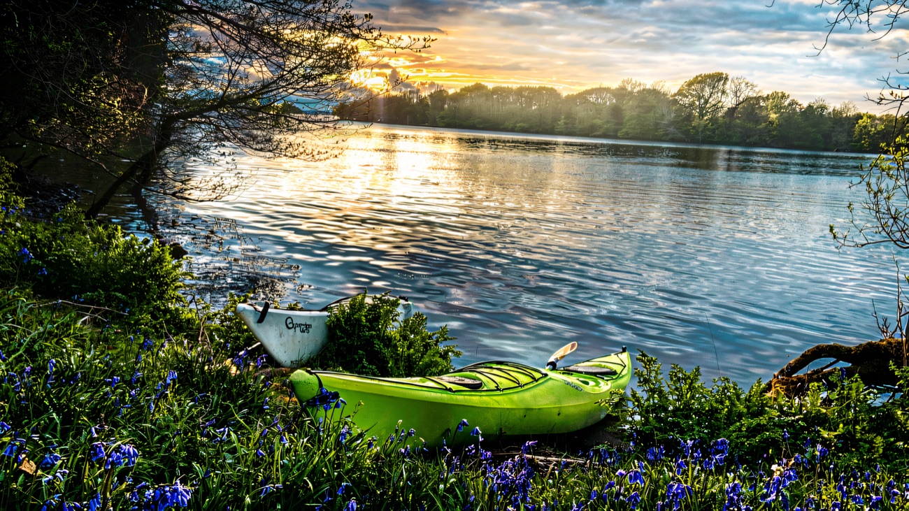 A kayak drawn up on a bluebell-covered bank beside the lough.