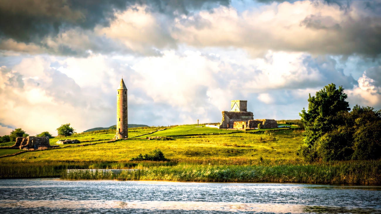 Devenish Island seen from the water, its ancient round tower and priory ruins on the green shore