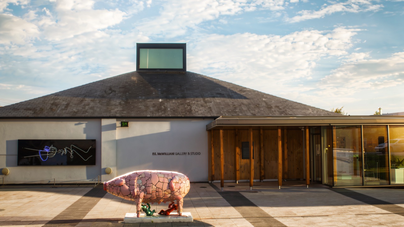 The gallery frontage and plaza with a painted pig sculpture