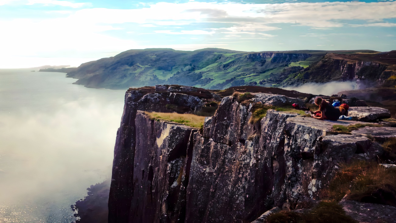The clifftop at Fair Head, with columns of rock dropping to the sea and the green coast beyond