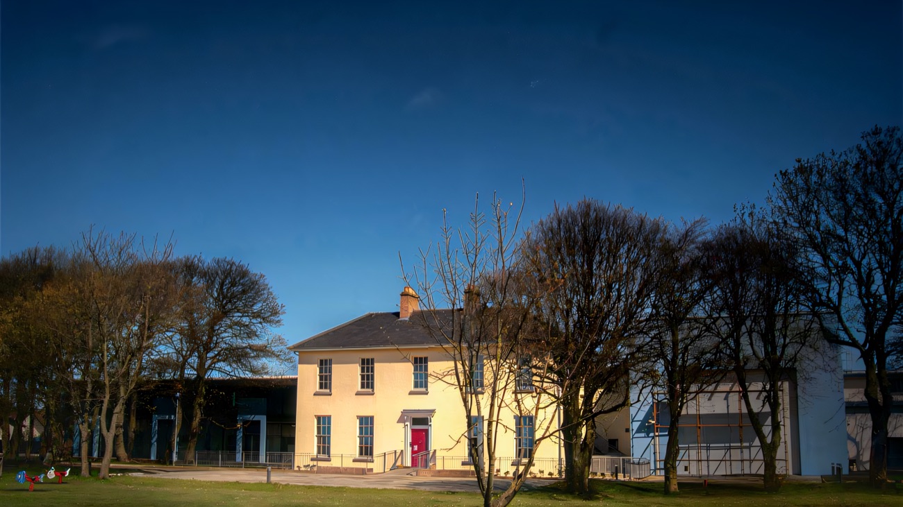 The Georgian house and modern wings under blue sky