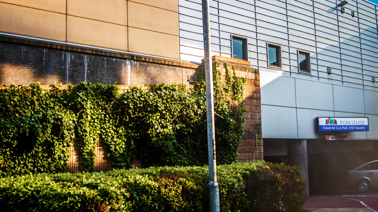 The covered car park entrance at Forestside, signposted for 650 spaces, off the road behind planted banks
