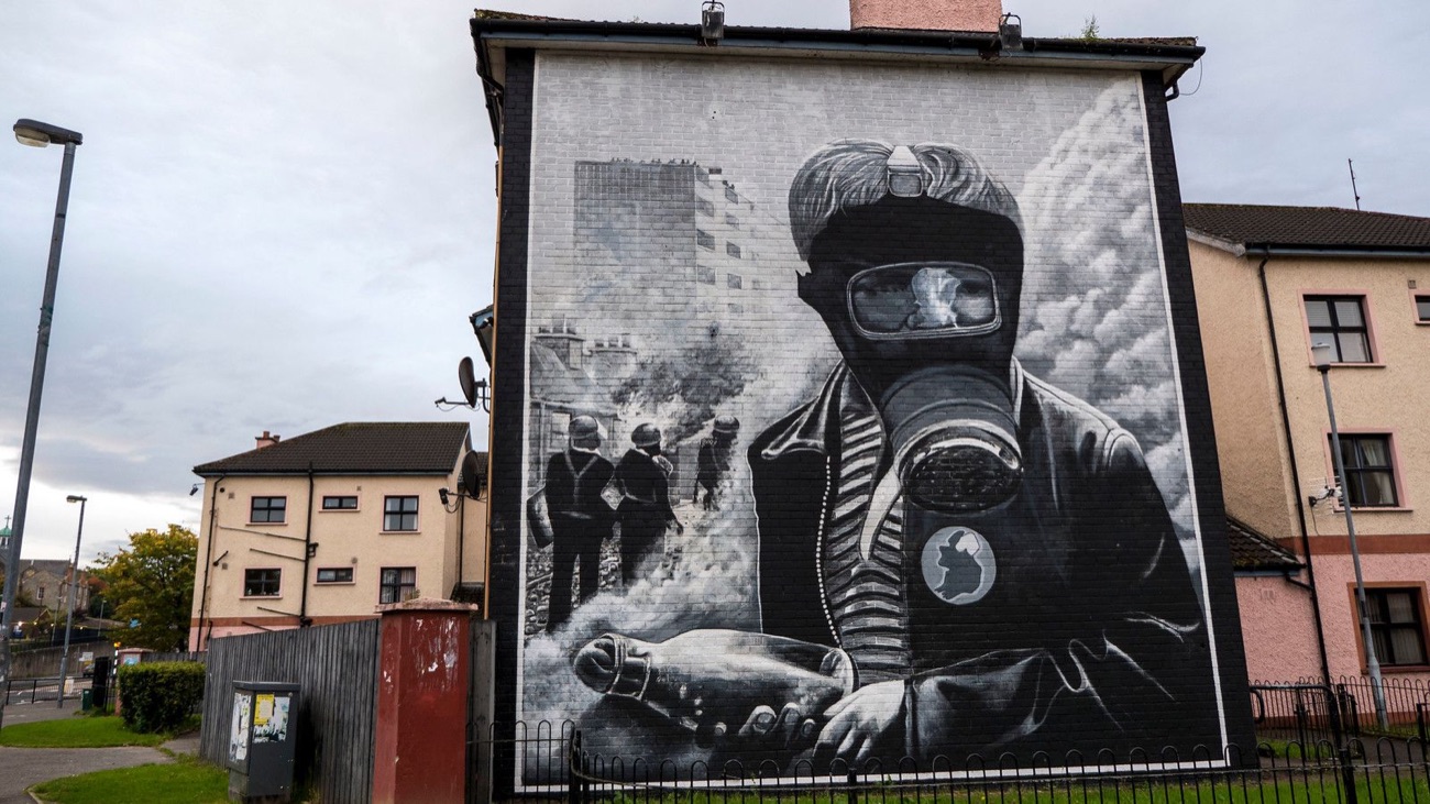 A large black-and-white People's Gallery mural on a house gable in the Bogside