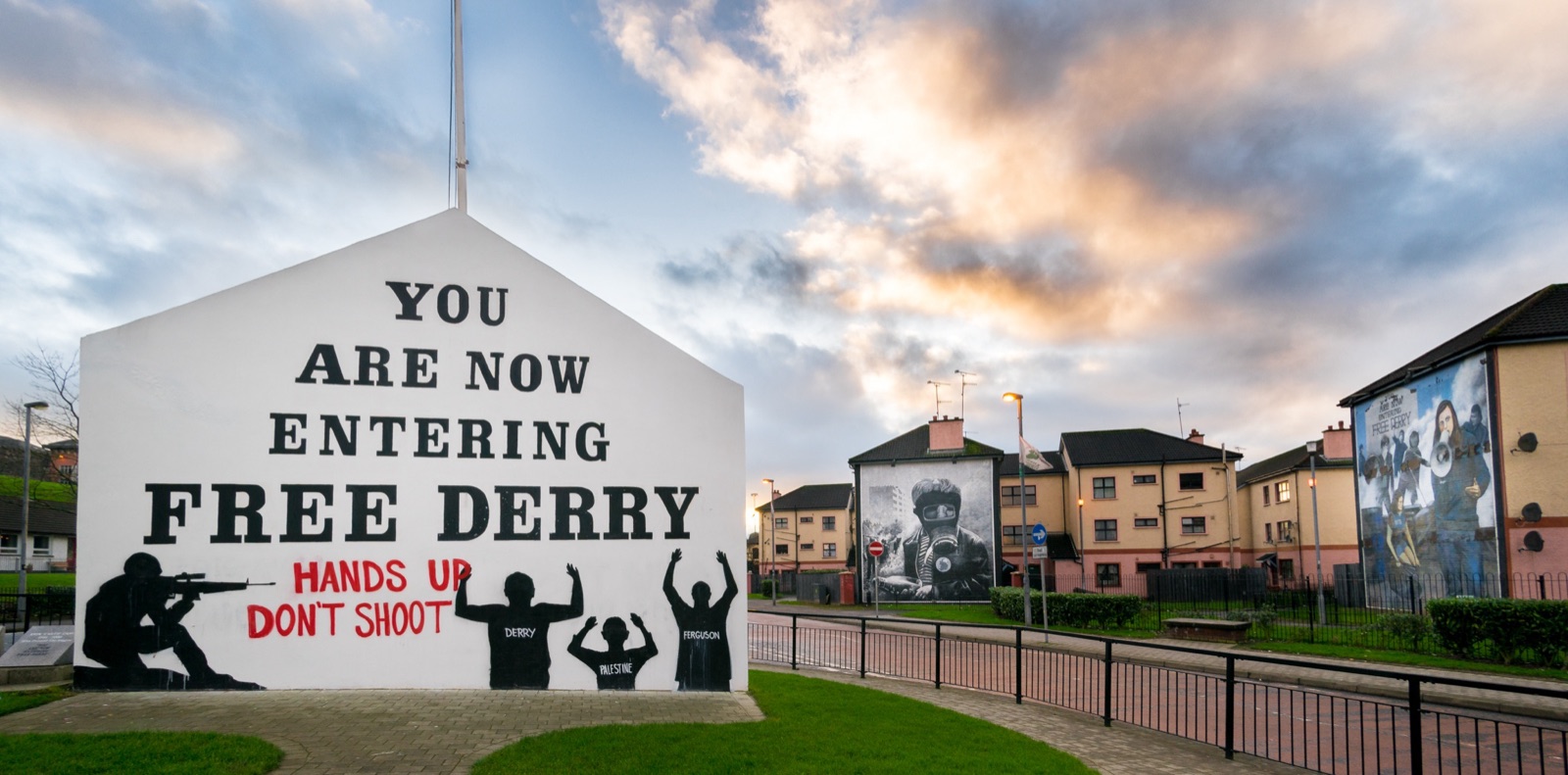The white gable wall reading 'You Are Now Entering Free Derry' with a People's Gallery mural and Bogside houses beyond