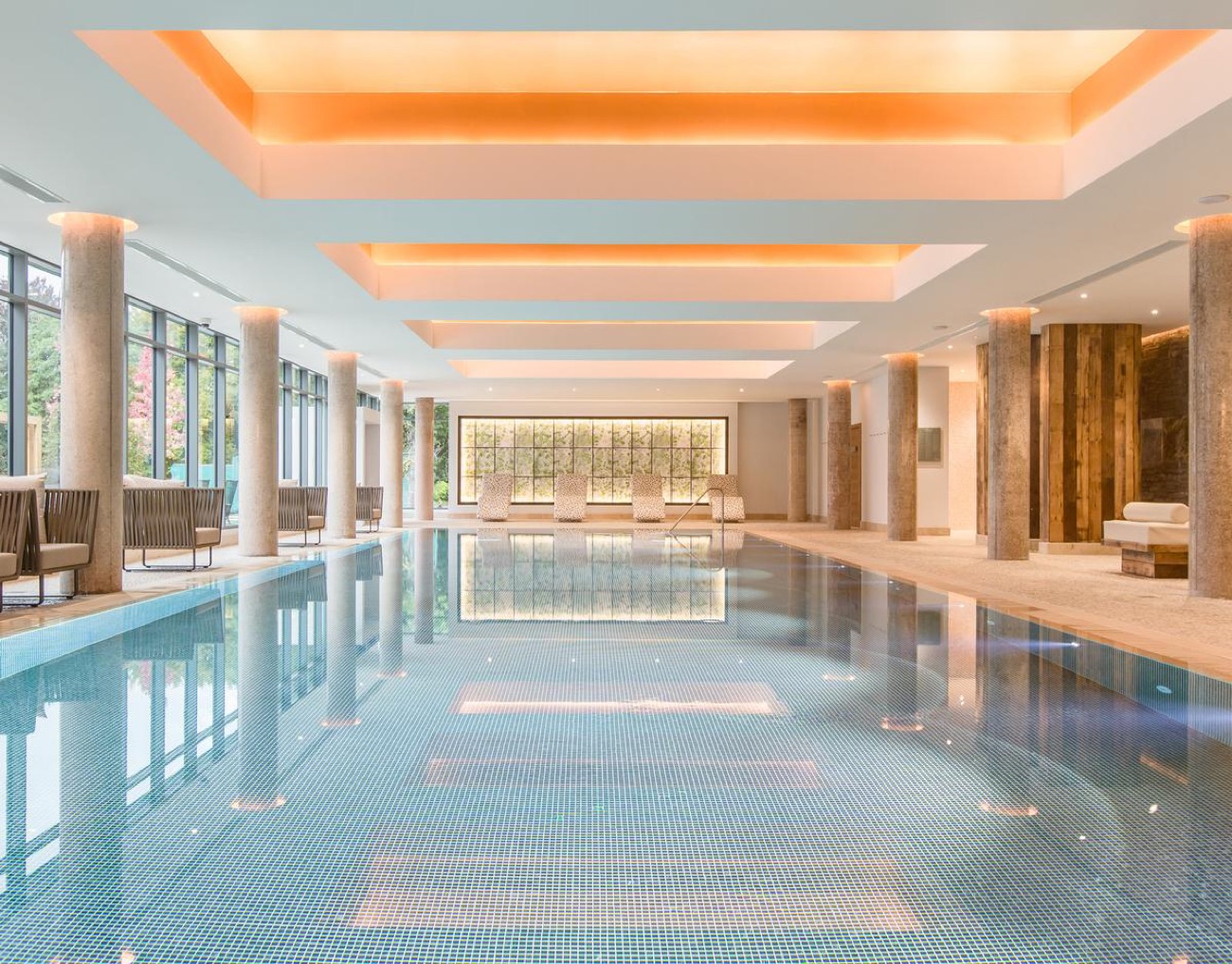 An indoor pool under a warm, softly-lit coffered ceiling at the Galgorm spa