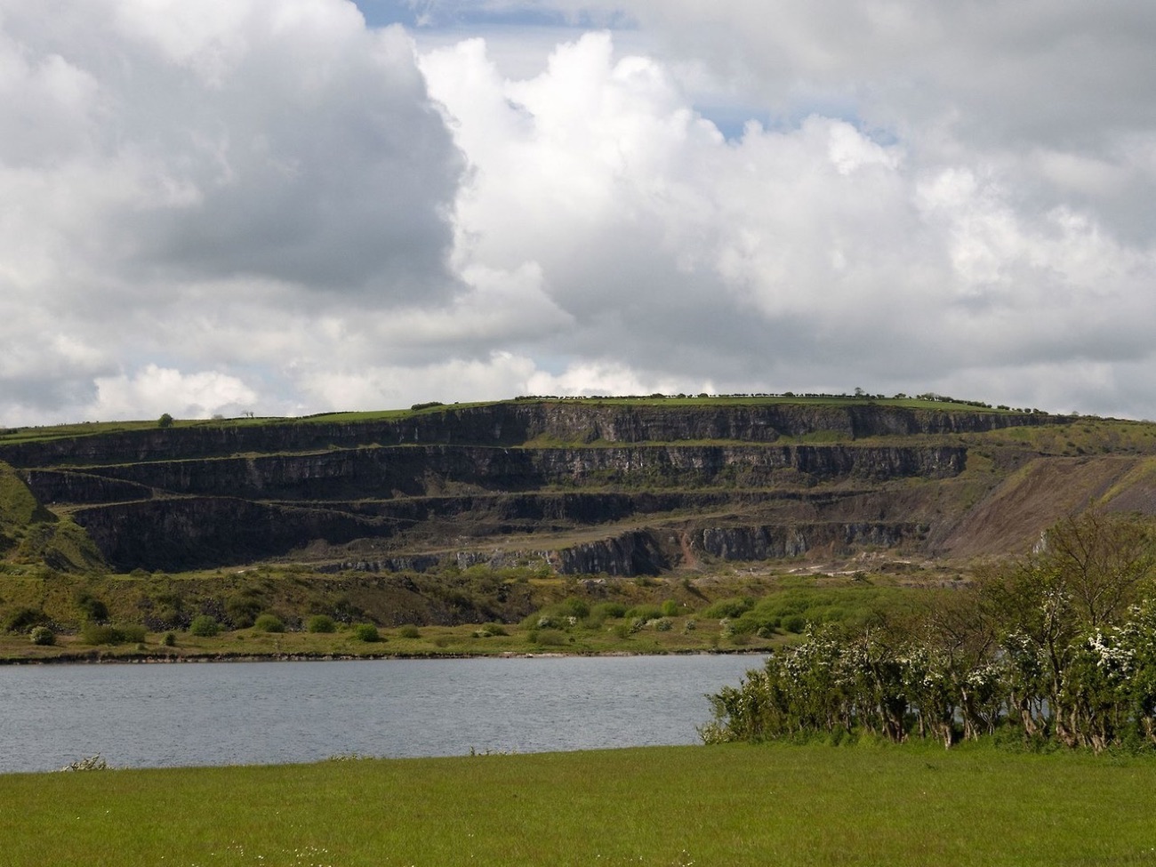 The terraced rock faces of Magheramorne Quarry seen from across the water