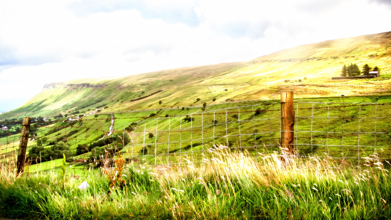 The green escarpment edge of the plateau falling away toward the glen and the Antrim coast.