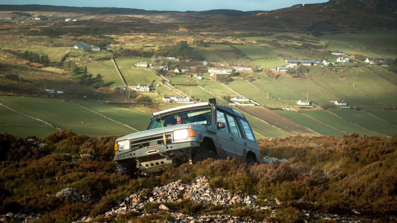A 4x4 picks its way across the open hillside above Glenarm