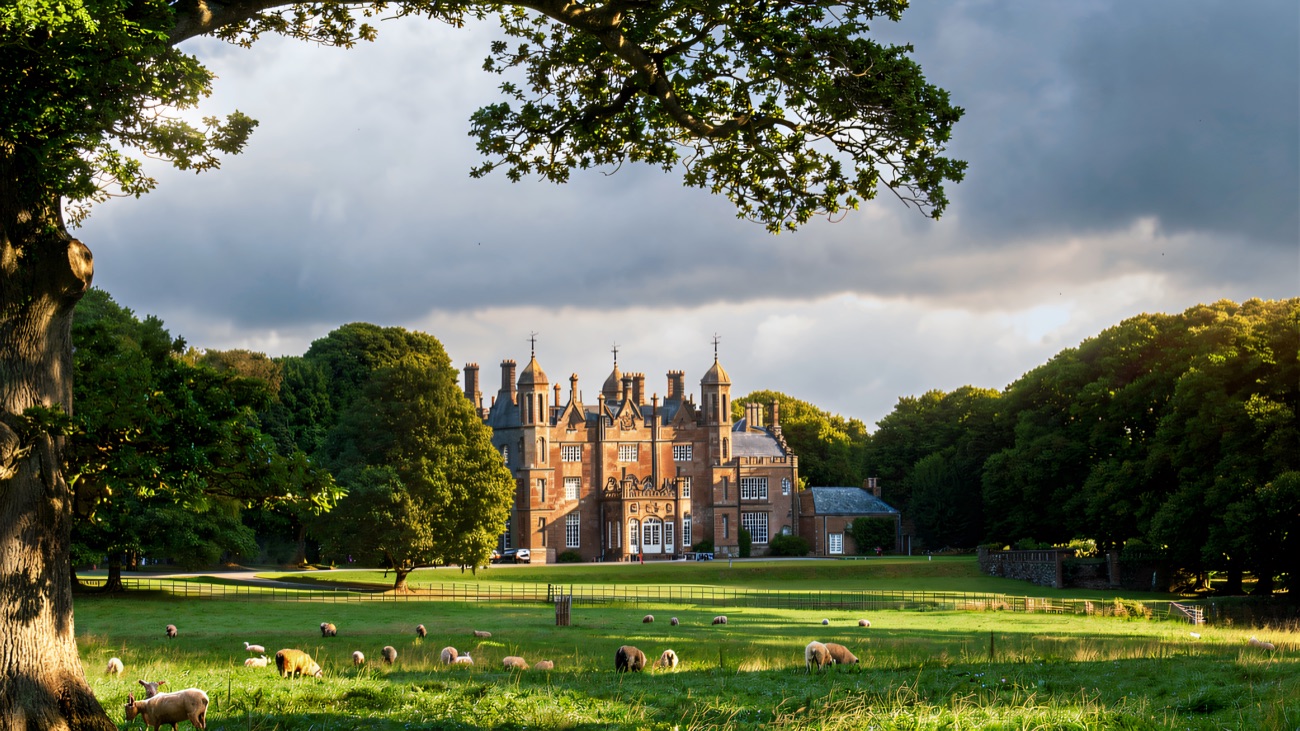 Glenarm Castle across its parkland, sheep grazing below