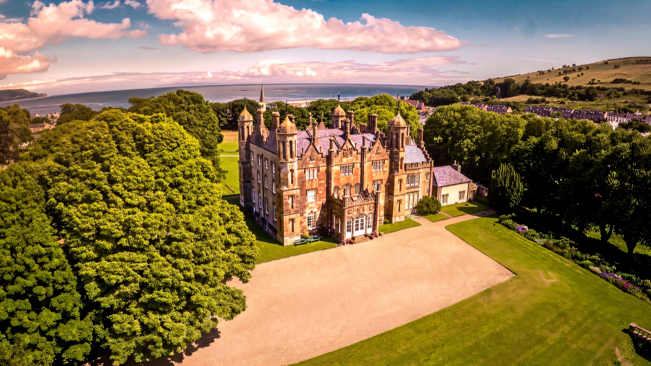 Glenarm Castle in its wooded estate with the Antrim coast and sea behind