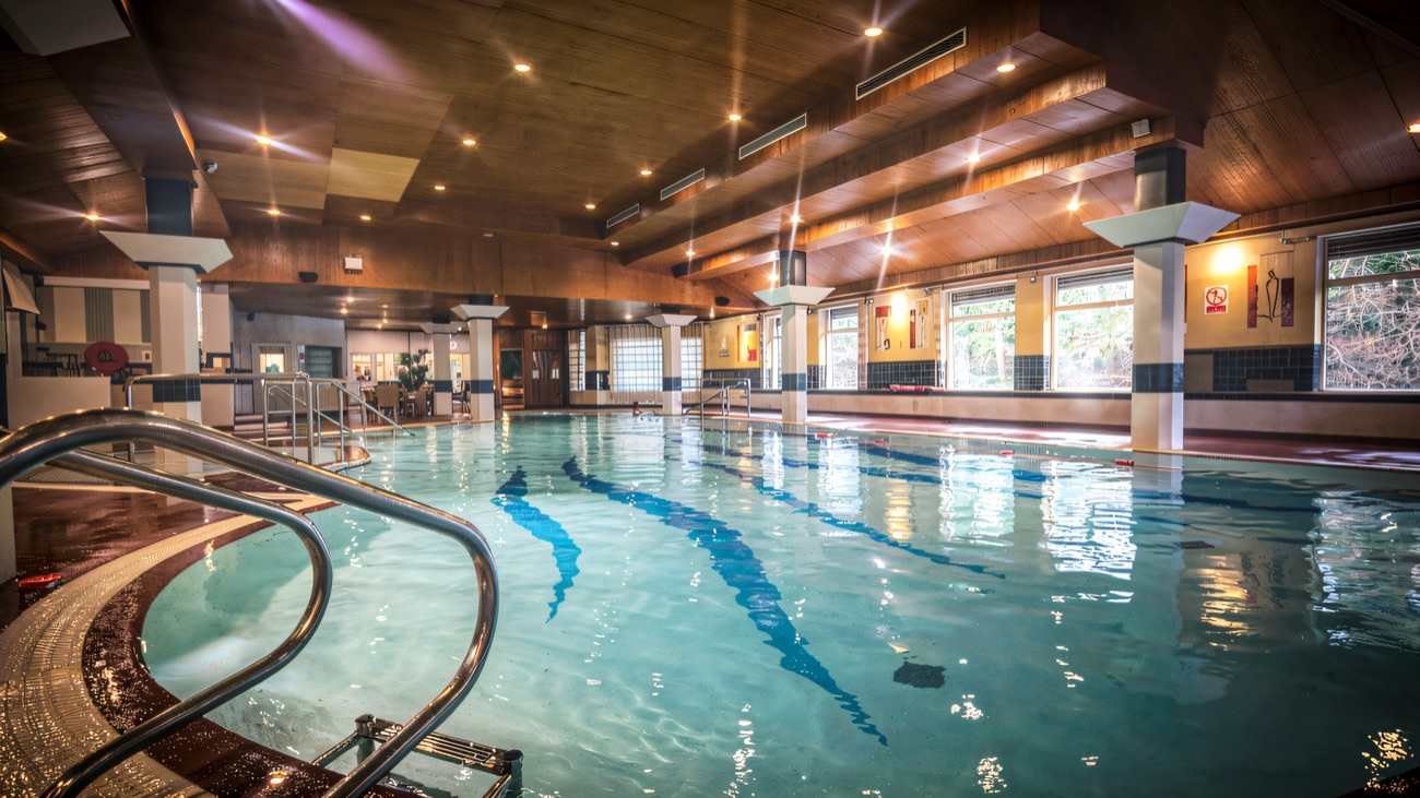 The 20-metre indoor pool, still and blue, seen from the steps in the corner.