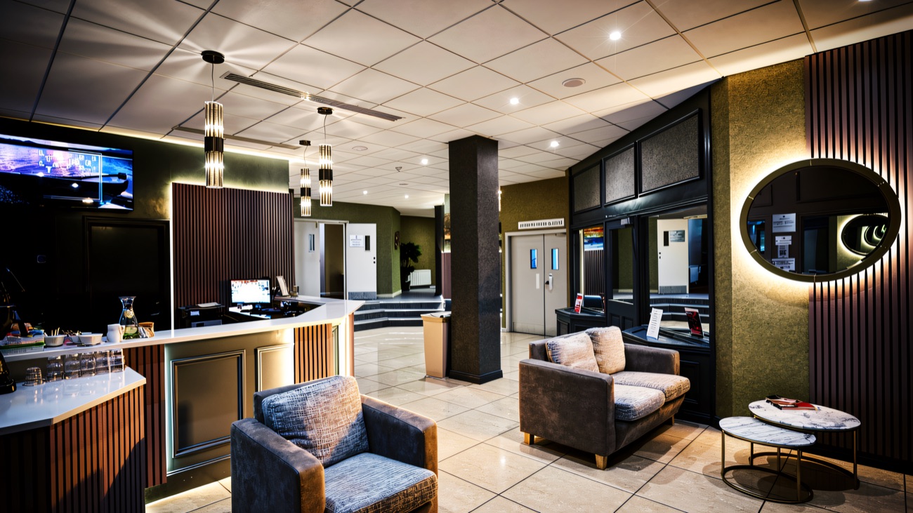 The leisure club reception and lounge, with soft grey chairs and warm lighting.