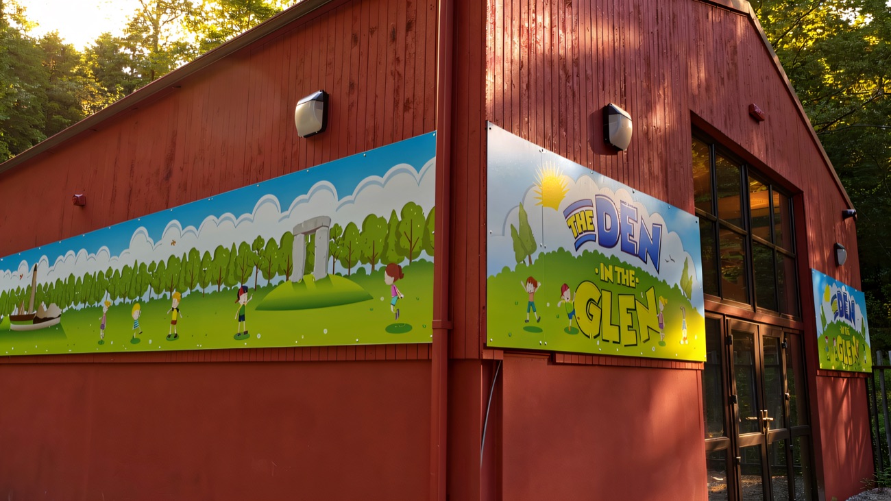 The red barn building painted with The Den in the Glen mural signage