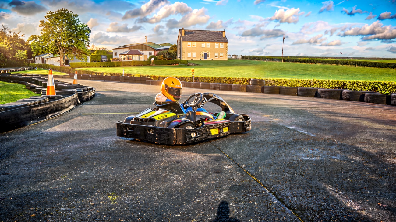 A kart sweeping through the bend under a big blue sky