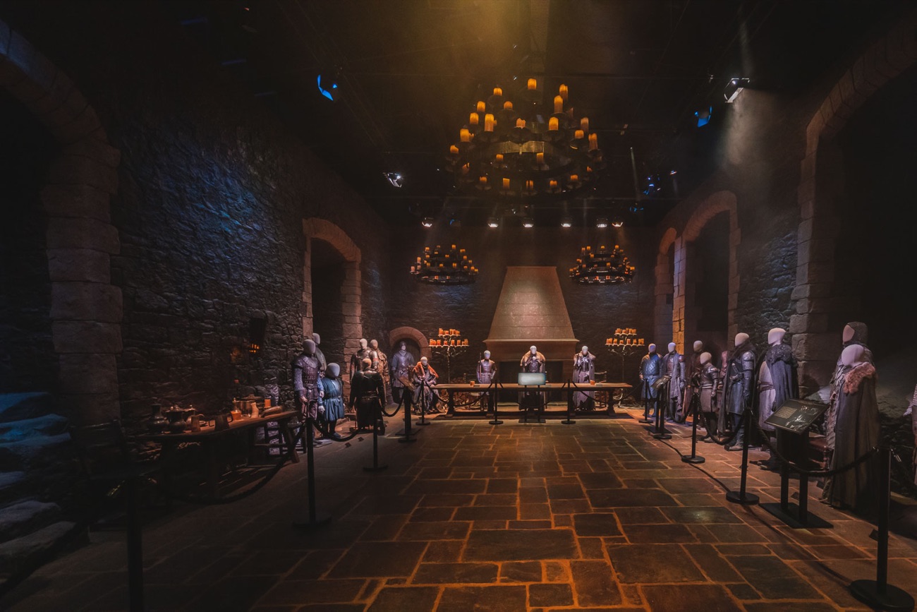 The Great Hall of Winterfell set, lit by candle chandeliers with costumed mannequins along the stone walls